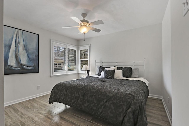 bedroom with ceiling fan, baseboards, and wood finished floors