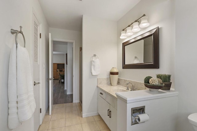 bathroom featuring tile patterned floors, baseboards, vanity, and toilet
