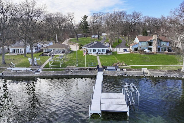 dock area with a residential view, a lawn, and a water view
