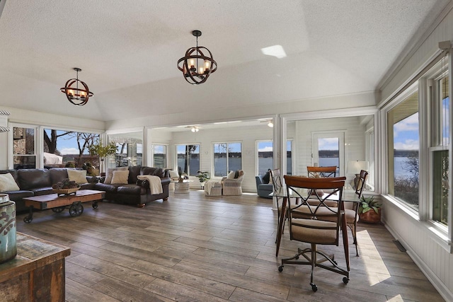 sunroom with a notable chandelier and a water view