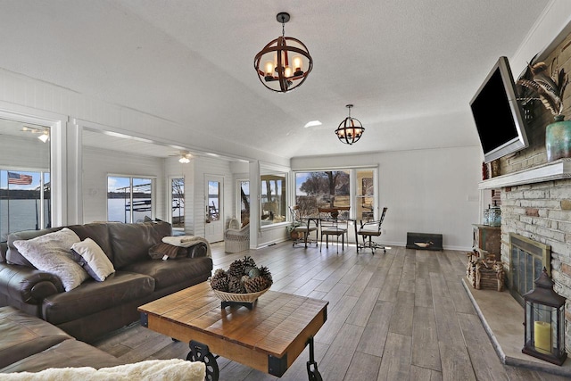 living room featuring wood finished floors, a brick fireplace, baseboards, and a healthy amount of sunlight