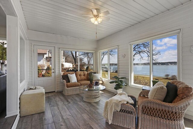 sunroom / solarium with a water view and hardwood / wood-style flooring