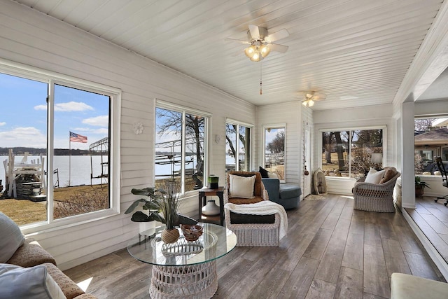 sunroom with hardwood / wood-style floors and a water view