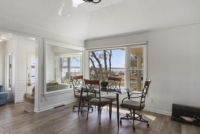 dining space featuring baseboards, a textured ceiling, and dark wood-type flooring