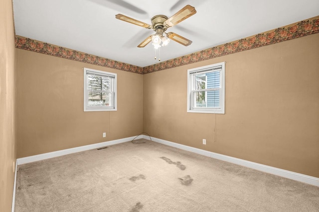 spare room with visible vents, plenty of natural light, baseboards, and carpet floors