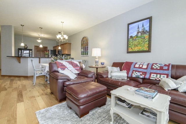 living area featuring baseboards, a chandelier, and light wood-style floors