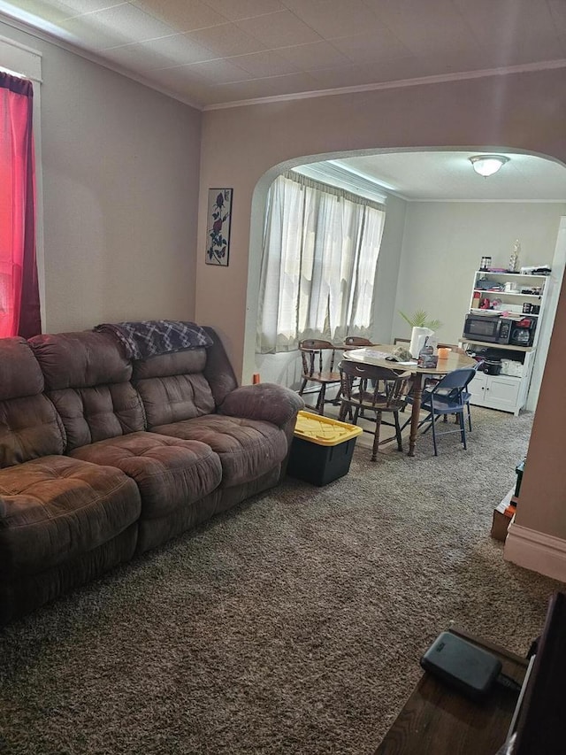 carpeted living room featuring arched walkways and ornamental molding