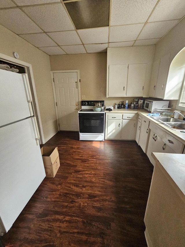 kitchen featuring white cabinets, dark wood finished floors, range with electric stovetop, a sink, and freestanding refrigerator