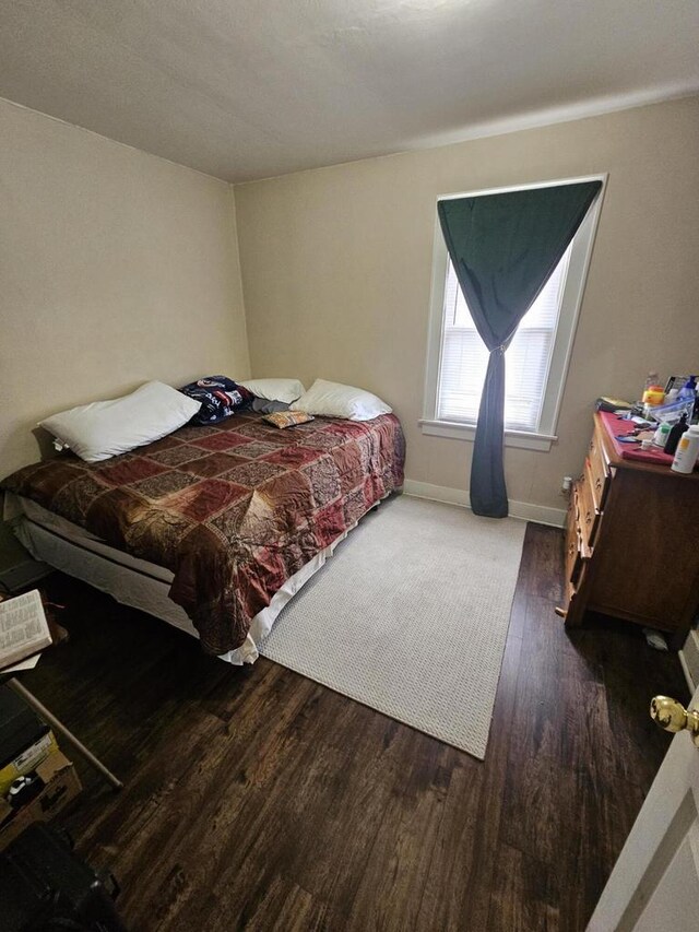 bedroom with baseboards and wood finished floors