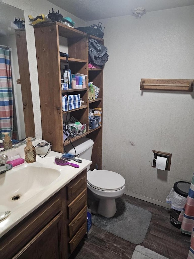 bathroom featuring wood finished floors, toilet, vanity, baseboards, and a shower with shower curtain