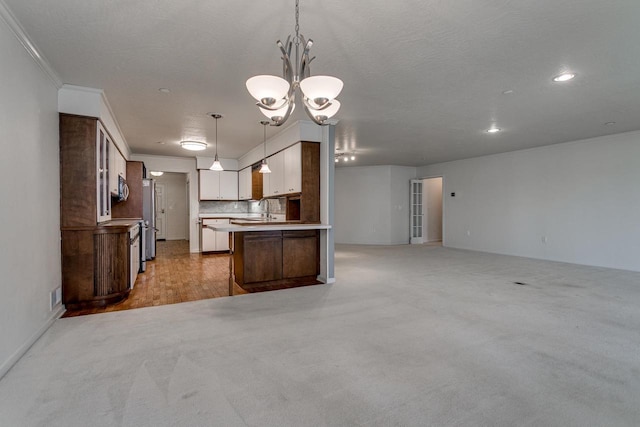 kitchen with open floor plan, a chandelier, light carpet, decorative light fixtures, and visible vents