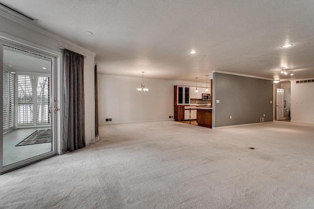 unfurnished living room with visible vents, crown molding, a chandelier, a textured ceiling, and light colored carpet