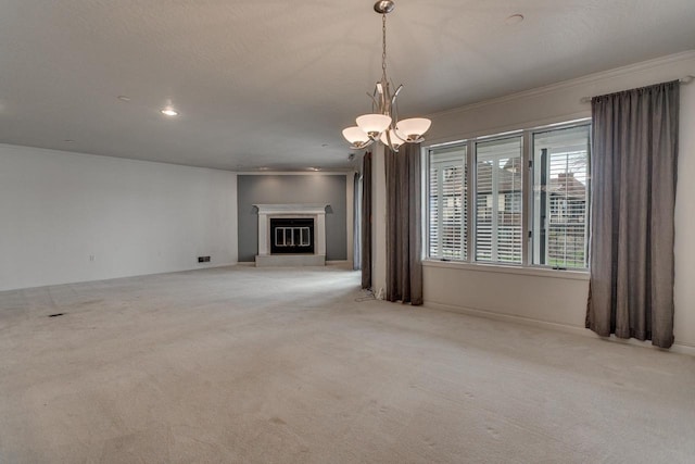 unfurnished living room featuring a glass covered fireplace, carpet floors, crown molding, and an inviting chandelier
