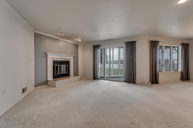 unfurnished living room with a textured ceiling, a fireplace, light colored carpet, ornamental molding, and visible vents