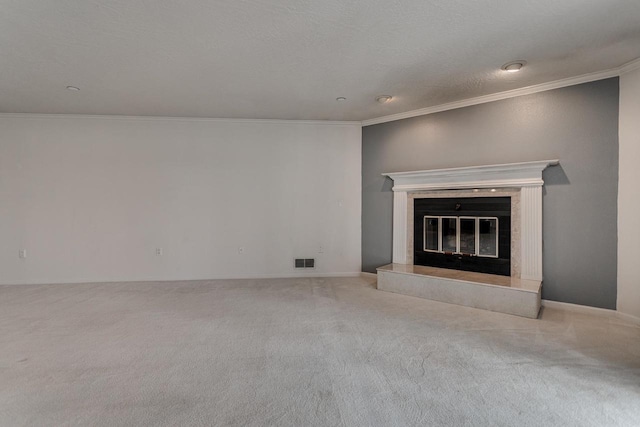 unfurnished living room with a fireplace, carpet floors, visible vents, and crown molding