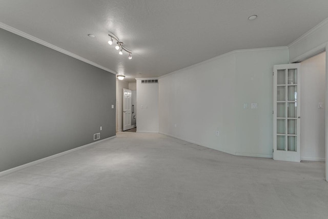 empty room with visible vents, crown molding, and light colored carpet
