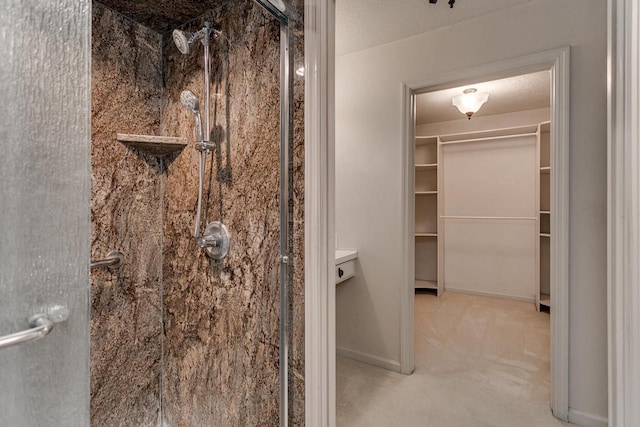 full bath featuring a spacious closet, baseboards, and a stall shower