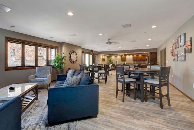 living room featuring baseboards, visible vents, recessed lighting, and light wood-style floors