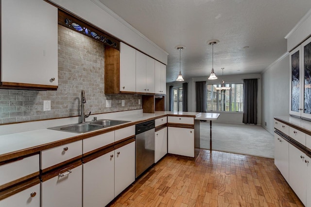 kitchen featuring white cabinets, light countertops, stainless steel dishwasher, and a sink