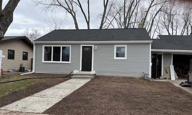 1610 S Oneida St, Green Bay, WI 54304 - view of front of property featuring a shingled roof, a chimney, and central air condition unit