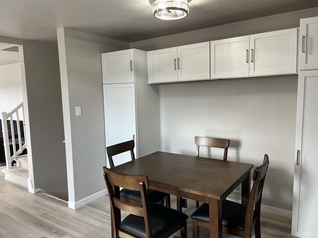 1610 S Oneida St, Green Bay, WI 54304 - dining space featuring light wood-type flooring, baseboards, and stairway