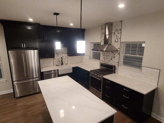 1323 W Lloyd St, Milwaukee, WI 53205 - kitchen featuring dark cabinets, stainless steel appliances, a sink, and wall chimney range hood