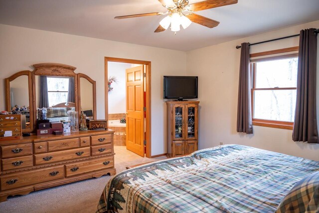 W3760 W Lemonweir Ct, Mauston, WI 53948 - bedroom featuring light tile patterned floors, ensuite bath, ceiling fan, and multiple windows