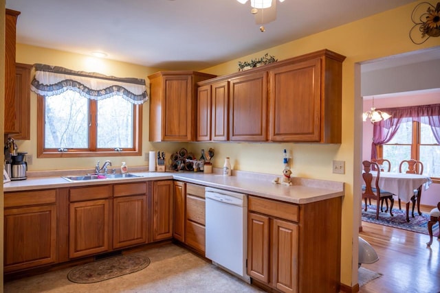 W3760 W Lemonweir Ct, Mauston, WI 53948 - kitchen featuring brown cabinets, white dishwasher, a sink, and light countertops