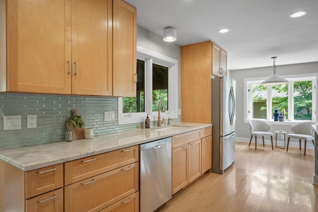 5308 Mckenna Rd, Monona, WI 53716 - kitchen with appliances with stainless steel finishes, a sink, backsplash, light wood-style flooring, and light stone counters
