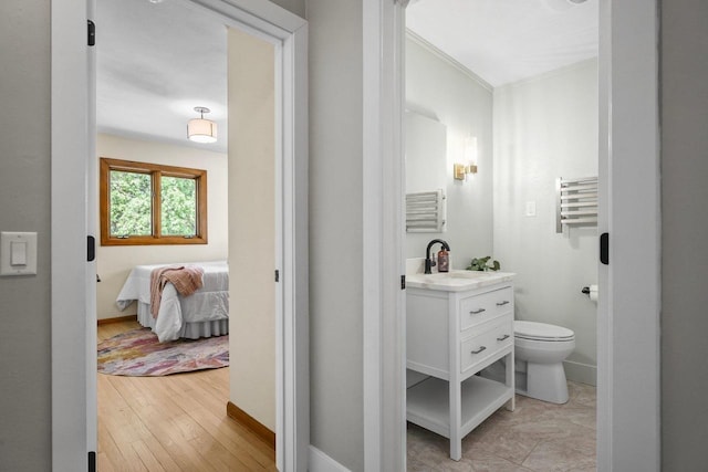 5308 Mckenna Rd, Monona, WI 53716 - bathroom featuring vanity, toilet, ornamental molding, baseboards, and wood finished floors