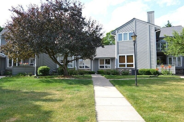 view of front of house with a chimney and a front yard