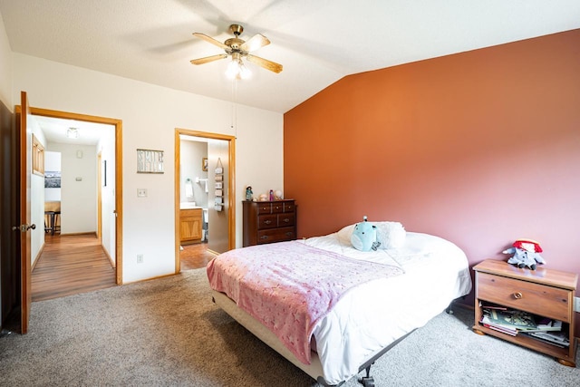 bedroom with carpet flooring, ceiling fan, lofted ceiling, and ensuite bath