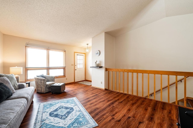 living area with a textured ceiling, wood finished floors, and baseboards
