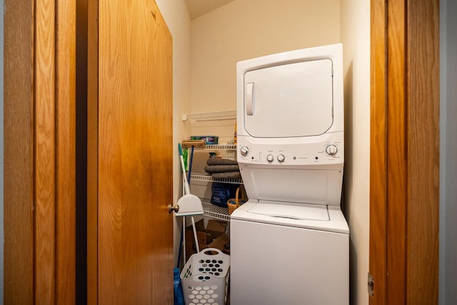 washroom featuring stacked washer and dryer and laundry area