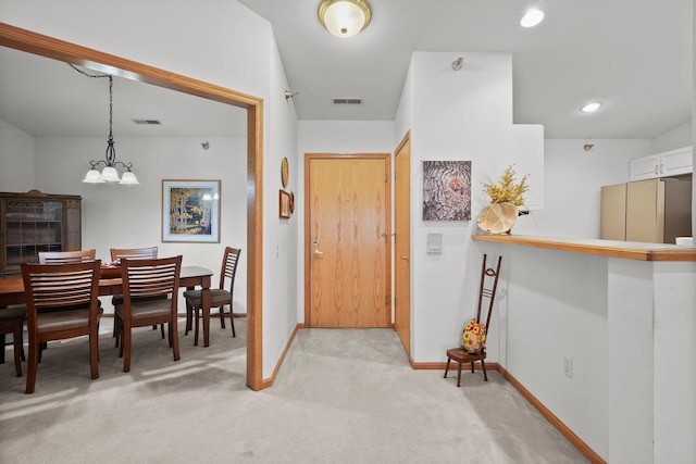 entrance foyer with light carpet, a chandelier, visible vents, and baseboards