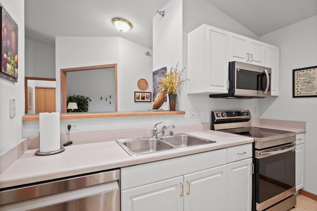 kitchen featuring a sink, vaulted ceiling, white cabinetry, light countertops, and appliances with stainless steel finishes