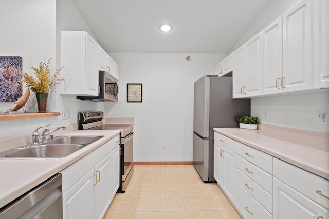 kitchen featuring stainless steel appliances, light countertops, a sink, and white cabinetry