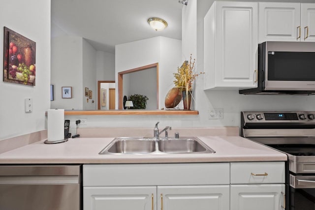 kitchen with white cabinets, appliances with stainless steel finishes, a sink, and light countertops