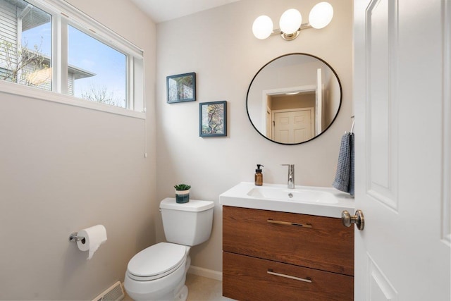 half bathroom featuring baseboards, toilet, and vanity