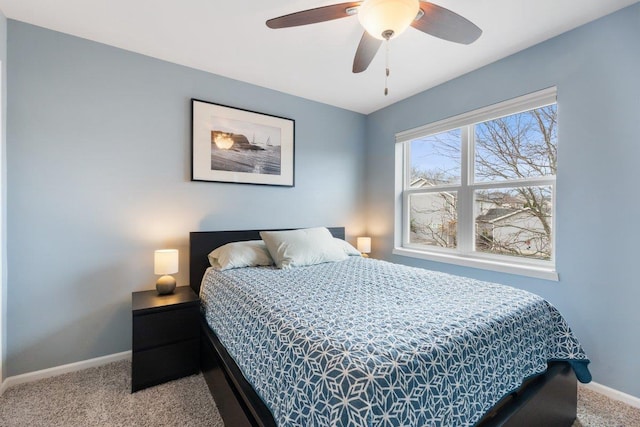 carpeted bedroom with ceiling fan and baseboards