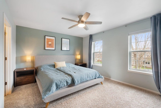 carpeted bedroom with a ceiling fan and baseboards