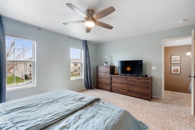 bedroom with ceiling fan, baseboards, and light colored carpet