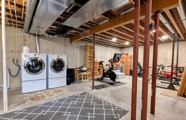 unfinished basement featuring visible vents and washing machine and clothes dryer