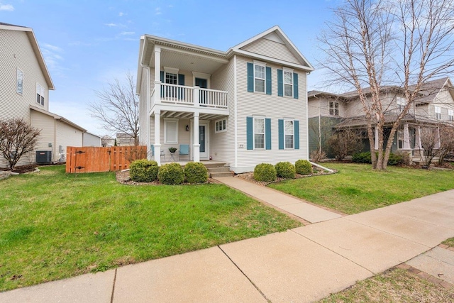 view of front of home featuring central AC, a front lawn, a balcony, and fence