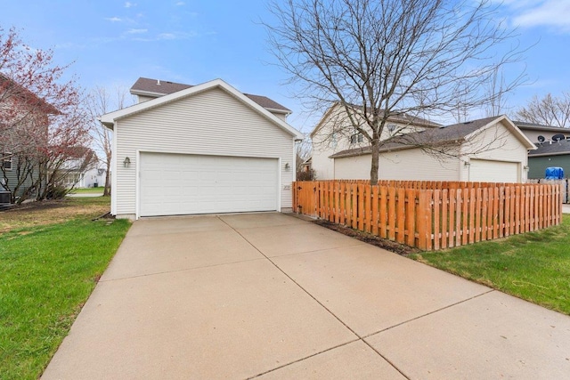 view of side of home featuring a garage, a lawn, and fence