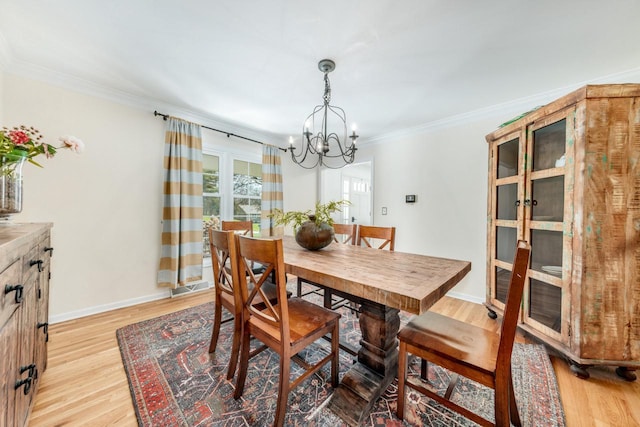 dining area featuring light wood finished floors, baseboards, visible vents, a notable chandelier, and crown molding