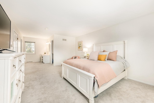 bedroom featuring baseboards, visible vents, and light colored carpet