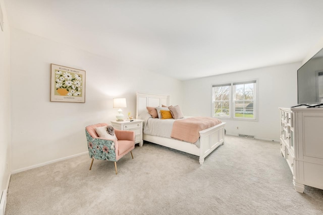 bedroom with baseboards and light colored carpet