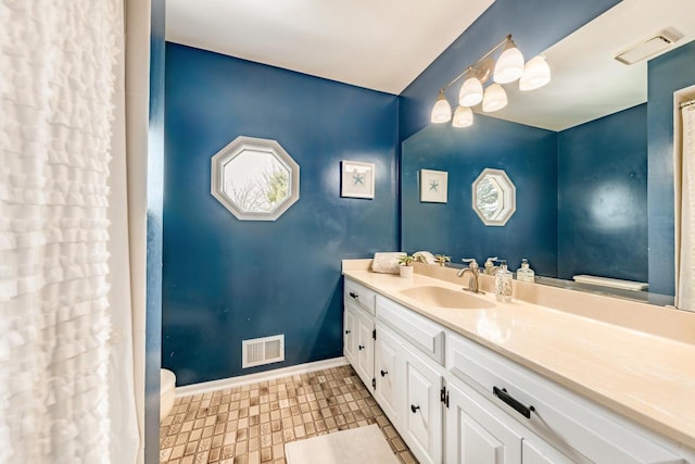 full bathroom with baseboards, toilet, vanity, and visible vents