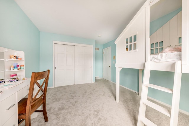 bedroom with light carpet, baseboards, and a closet